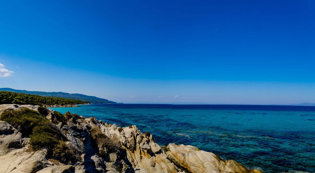 Rotsachtige kust met helder blauw water in Griekenland