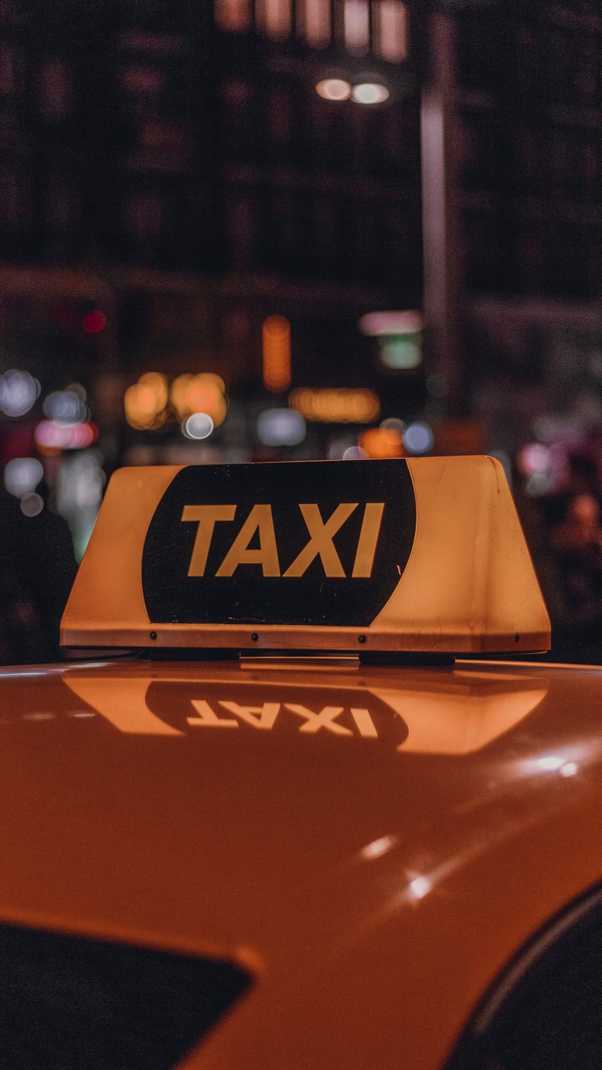 Verlicht oranje taxibordje op het dak van een wagen
